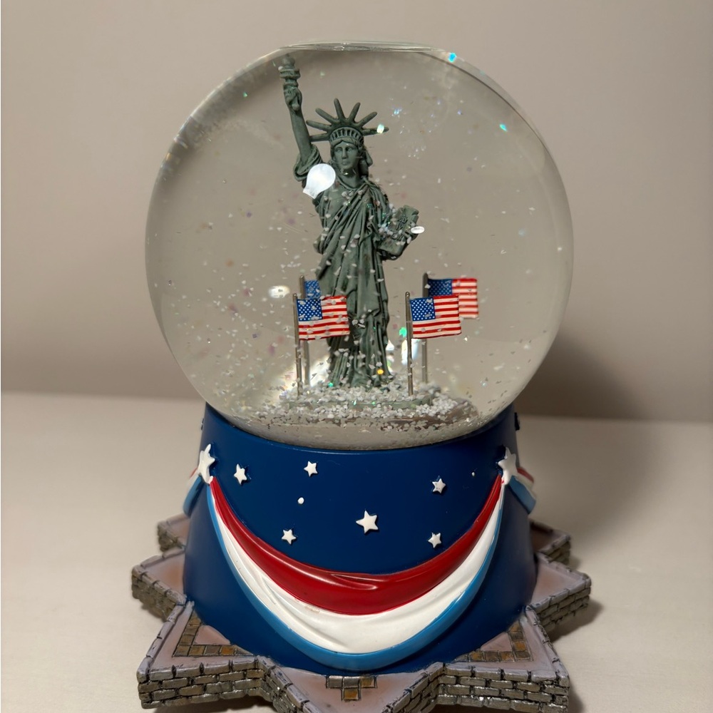 Statue of Liberty Snow Globe with American Flags by Hallmark. Water is clear.